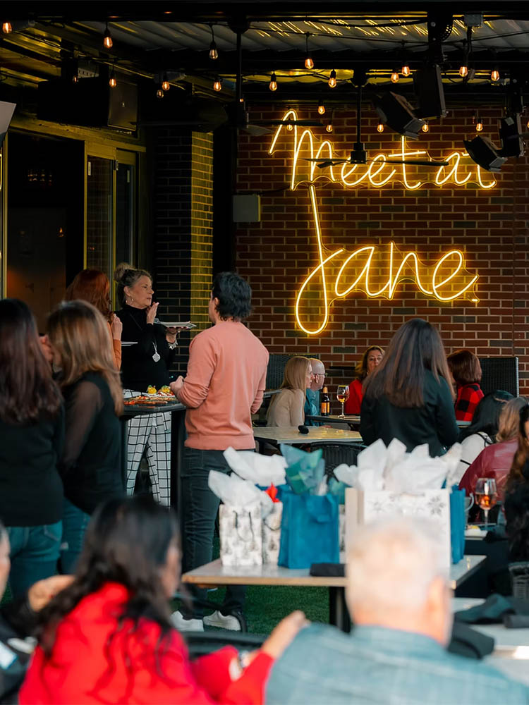 Guests gathered at a private event on the Jane Southlake patio under the Meet at Jane neon sign